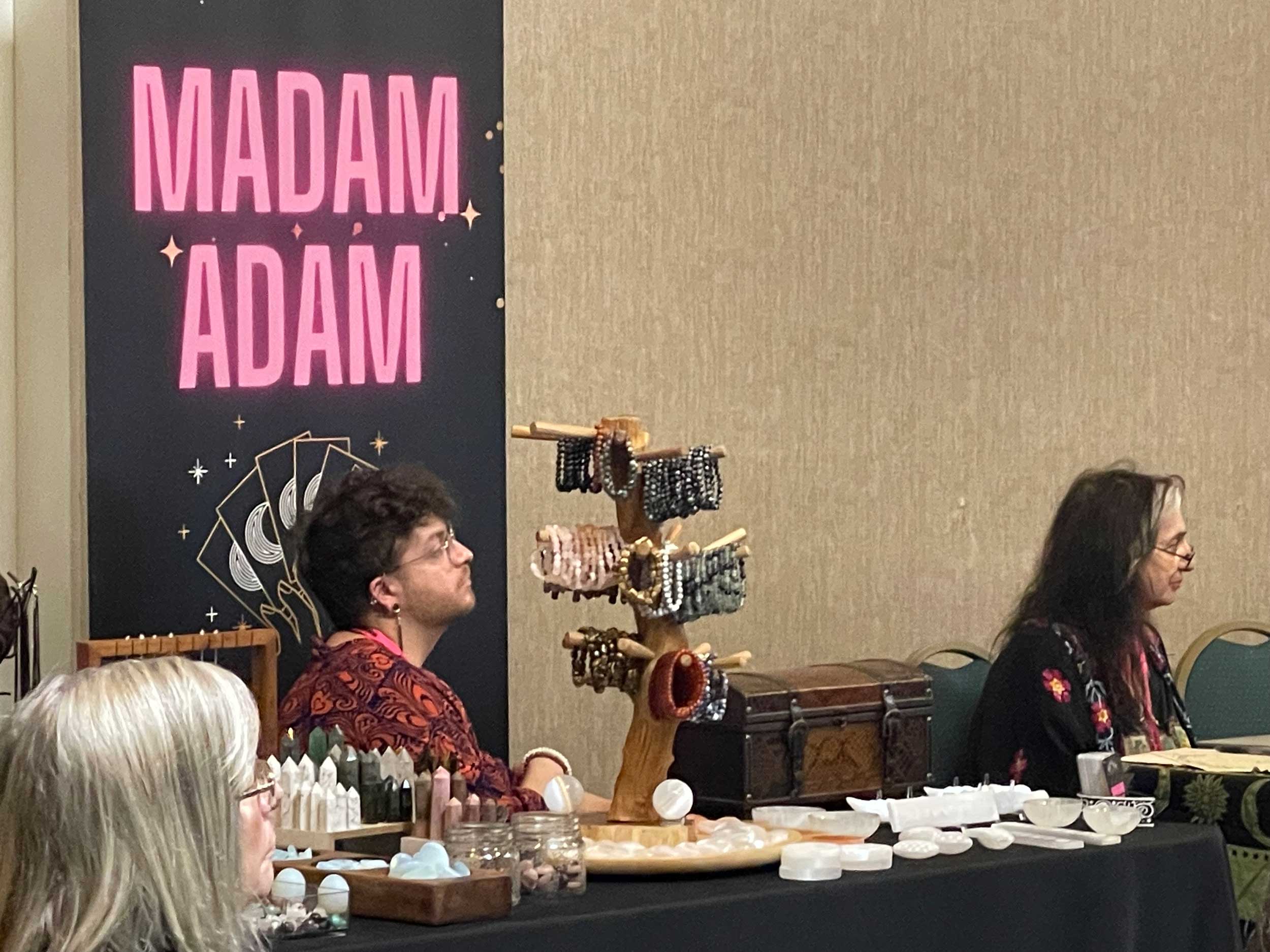 Madam Adam at their table at StaarCon 2023.